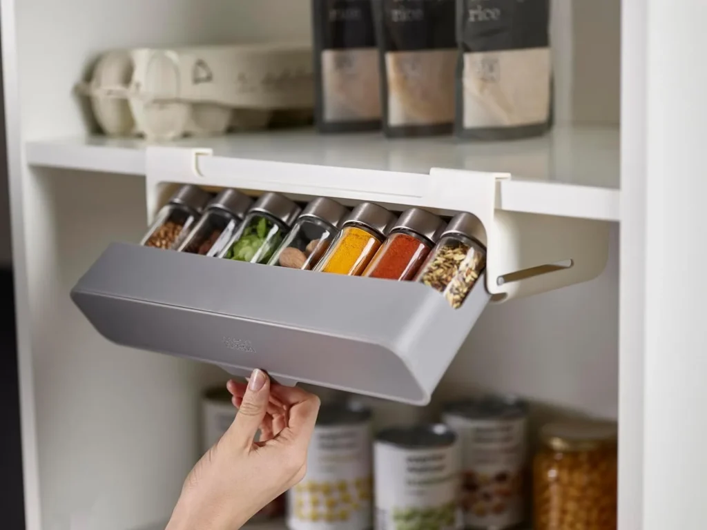 A well-organized kitchen countertop displaying 9 Amazon kitchen organization gadgets, including a spice and vitamin organizer, utensil holder, and beer can organizer, all trending on TikTok. The products are modern, sleek, and arranged to highlight a clutter-free and stylish kitchen space.