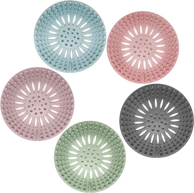 5-Pack of Gotega Hair Catcher Shower Drain Covers in multiple colors (grey, blue, green, pink, and brown), made of flexible Thermo-Plastic-Rubber. Designed for Western bathrooms, these easy-to-install drain protectors prevent hair clogs and are suitable for sinks, showers, and tubs.